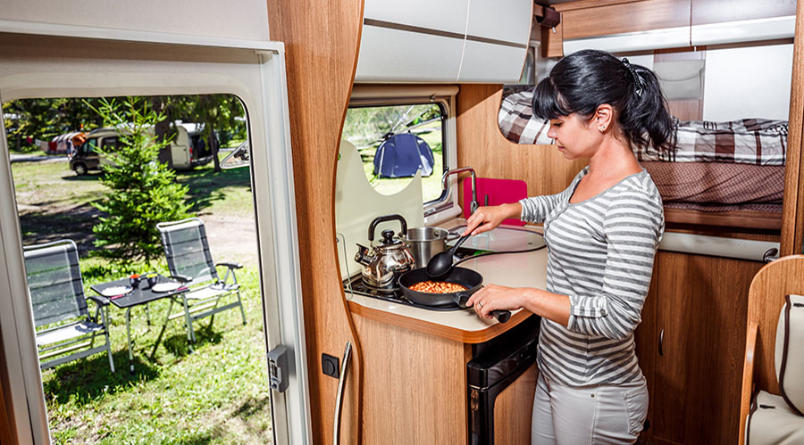 woman cooking inside a caravan